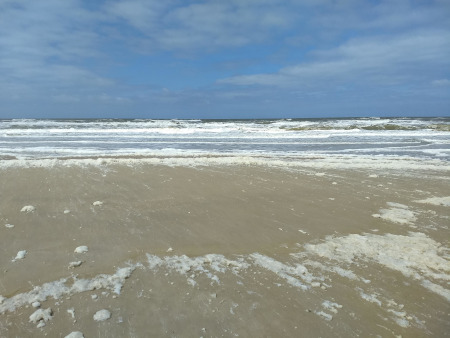 schuimvlokken op het strand